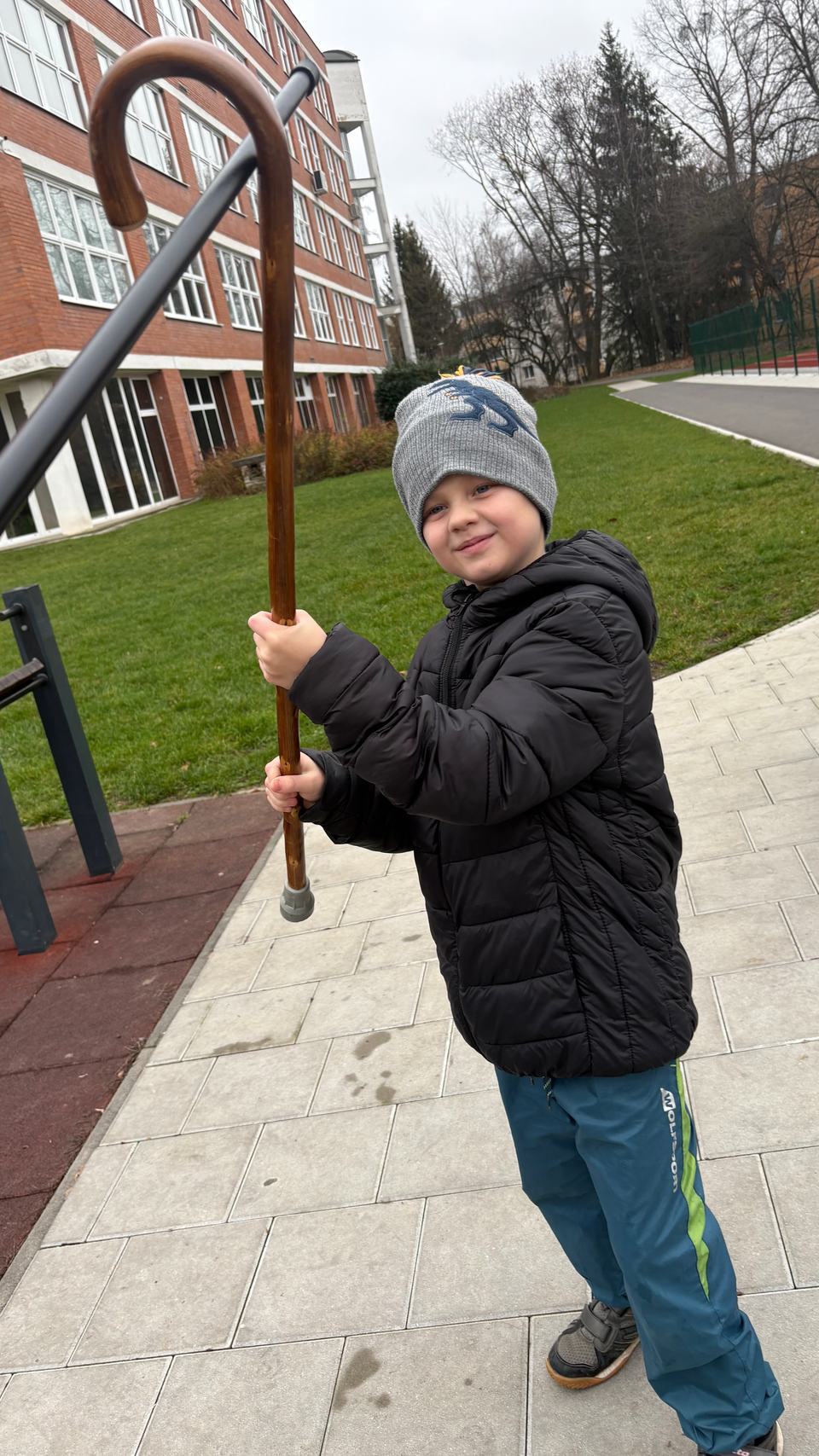 A boy outdoors with a long staff